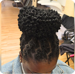 Top view of a black woman who got her dreadlocks done and tied into a ponytail at Tete Hazel