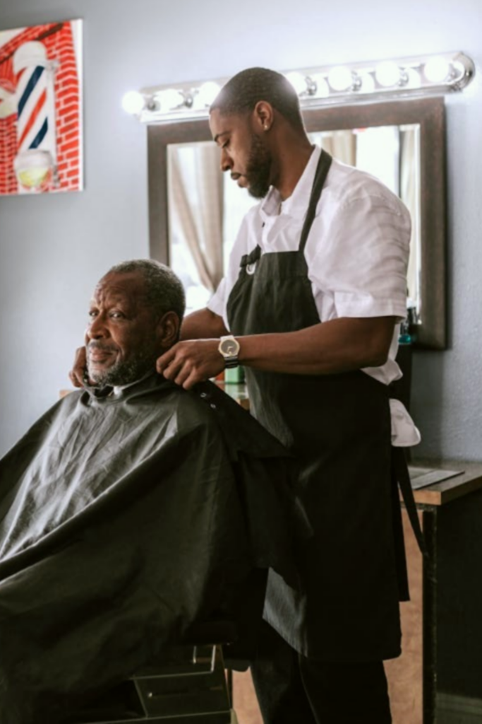 A barber preparing to cut a man's hair