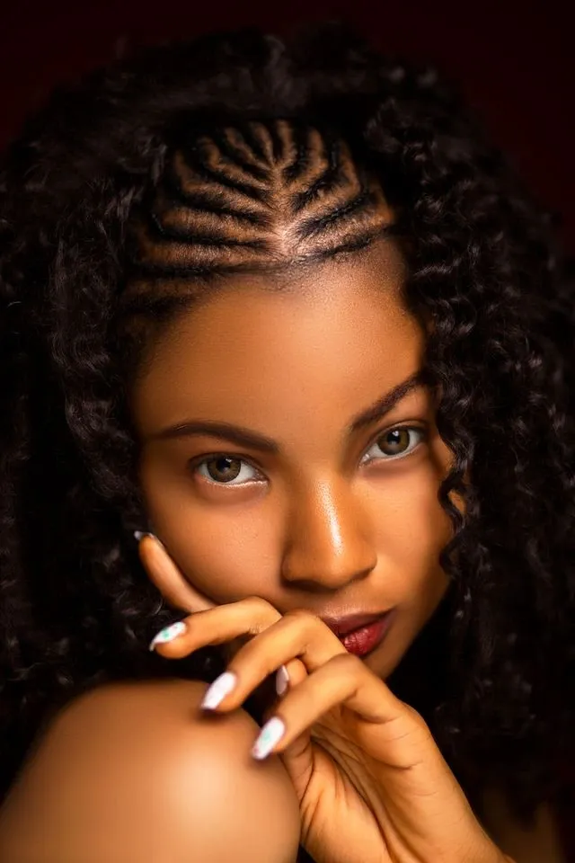 A woman with cornrows and a sew in weave hairstyle