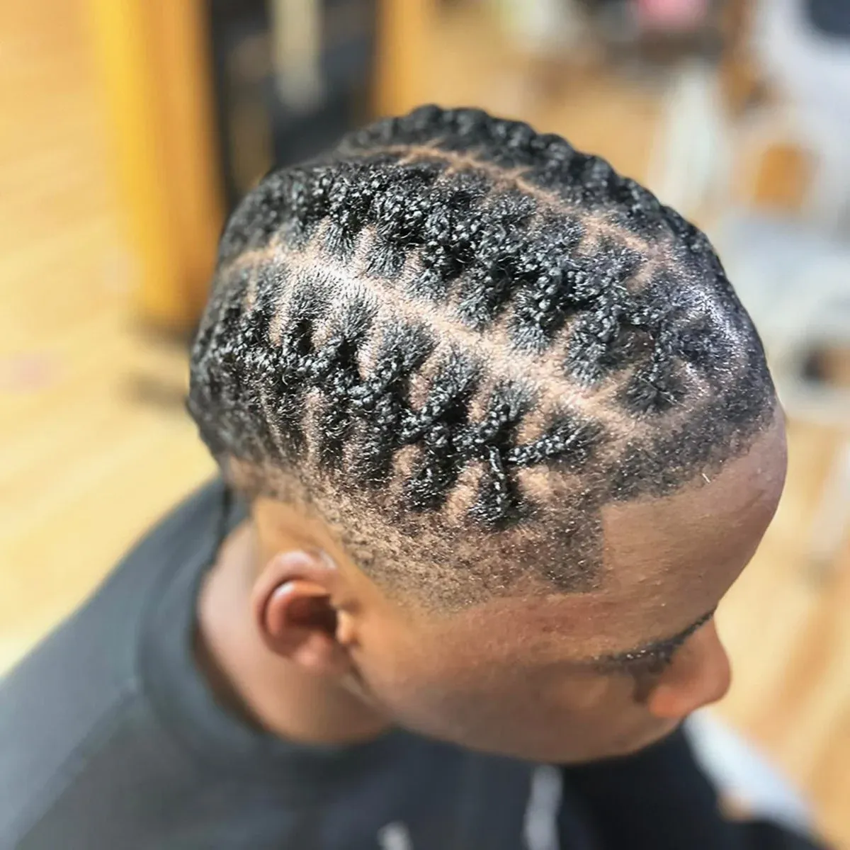 A man with a cornrows hairstyle done at Tete Hazel hair salon